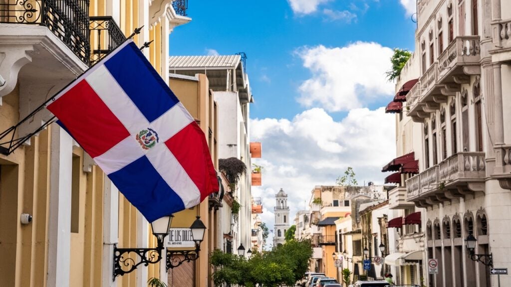 The Dominican Republic flag over the streets of a town.
