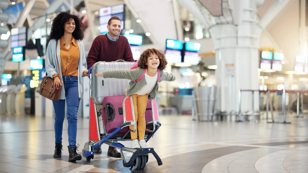 Airport, family and child excited for flight with suitcase trolley