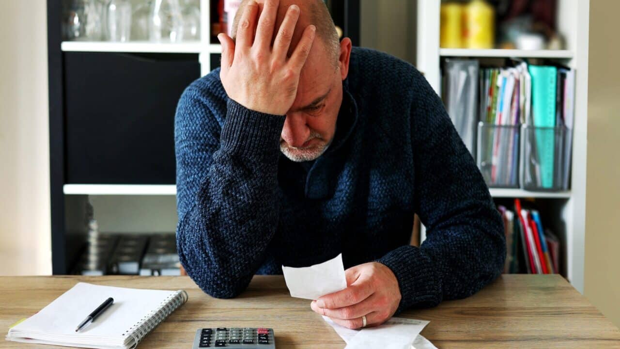 Man going over finances scaled e1691476899631
