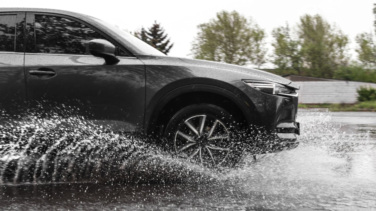 Modern car driving outdoors on rainy day