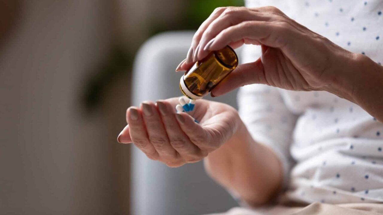 Close up mature woman taking out pills from bottle, supplements or antibiotic, older female preparing to take emergency medicine, chronic disease, healthcare and treatment concept