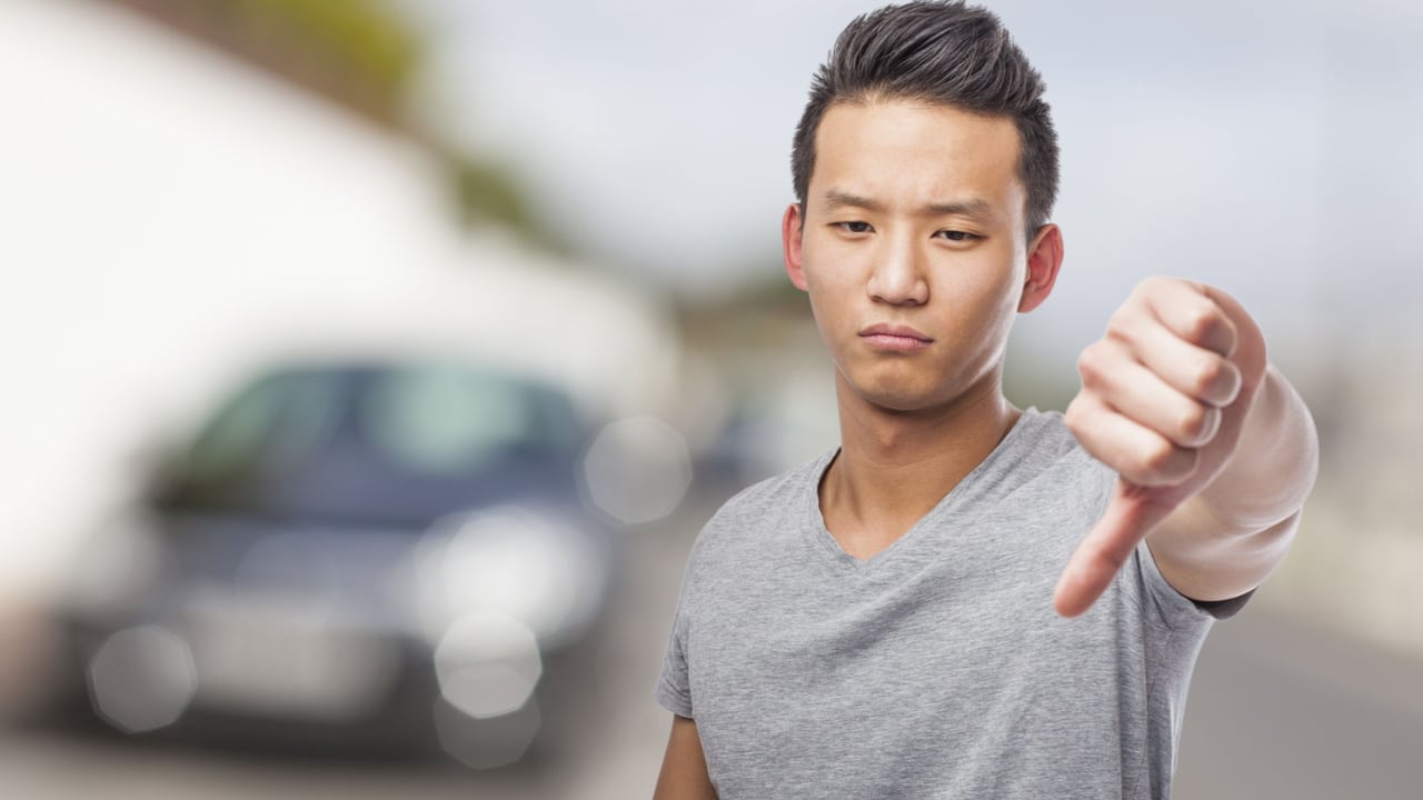 portrait of young asian man disliking electric car