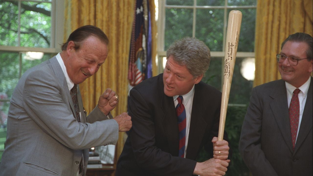 President Bill Clinton poses with a baseball bat in the Oval Office after receiving it from St. Louis Cardinals Hall of Famer Stan Musial.