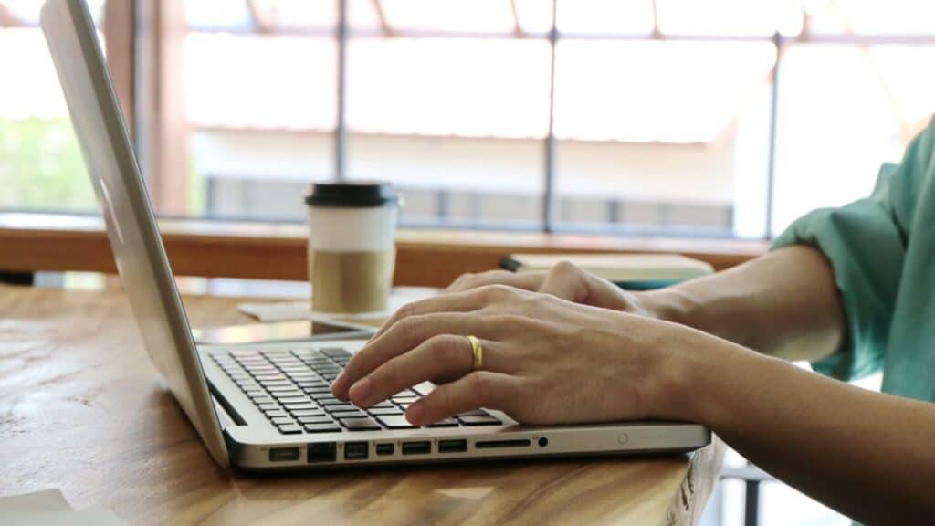 Person working at their laptop, starting a side hustle to make extra cash.