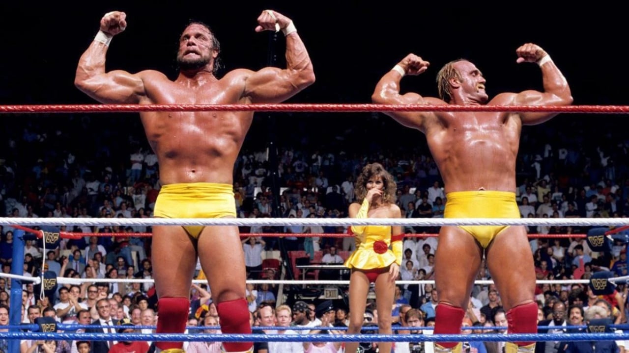 Randy Savage and Hulk Hogan flex in front of Ms. Elizabeth Hulette at The Mega Powers vs The Mega Bucks