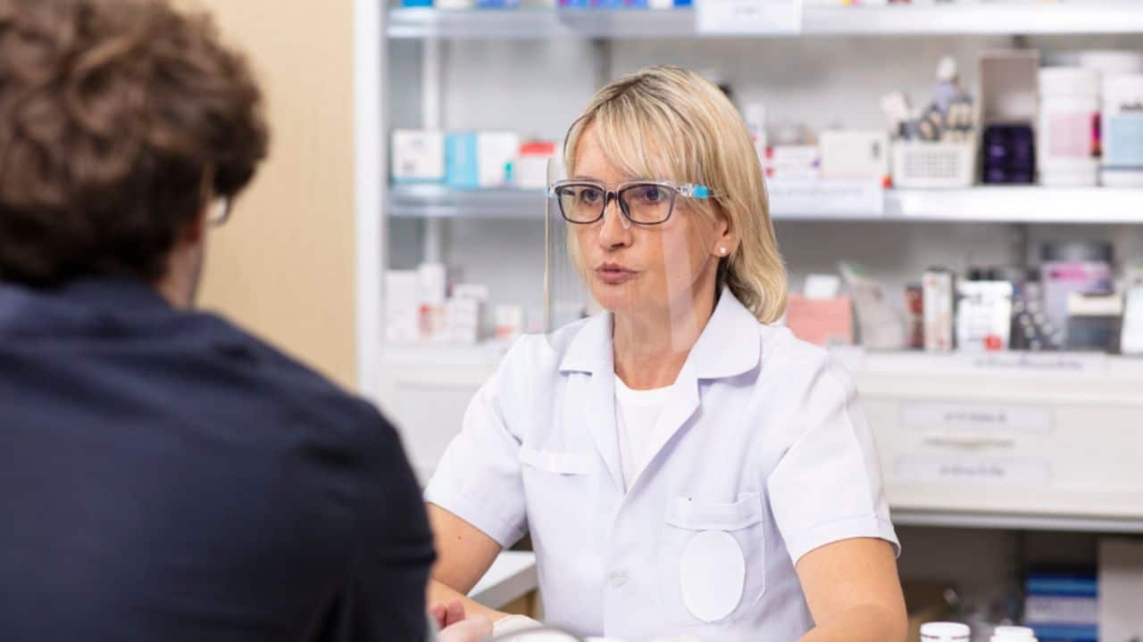 Woman Phamacist wearing facemask take assit to patient in Pharmacy shop