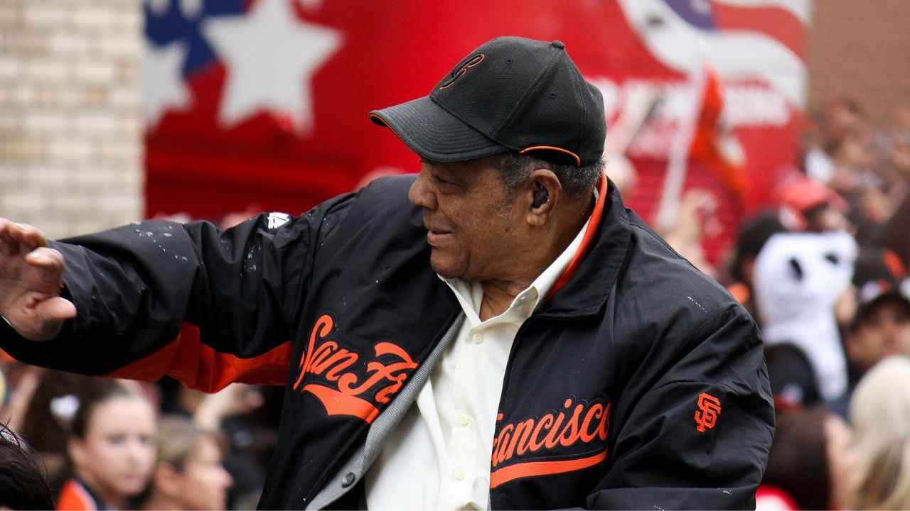 Willie Mays waving to a crowd during a parade.