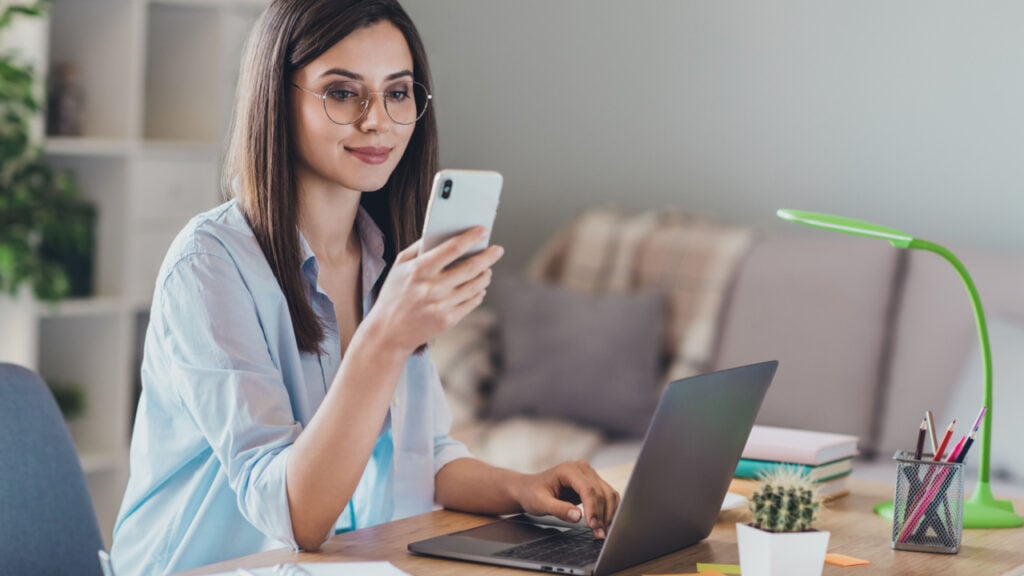 woman with glasses home office computer phone workspace